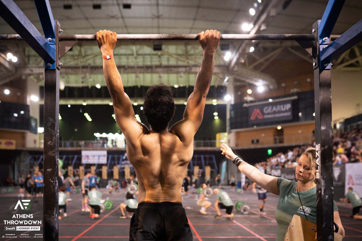 judge counting reps of male athlete on the bar